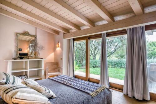 een slaapkamer met een bed en een groot raam bij Luxury Villa in Porto Rotondo in Porto Rotondo