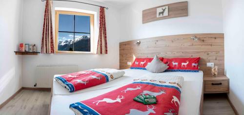 a bedroom with a bed with red pillows and a window at Pirchachhof in Wenns