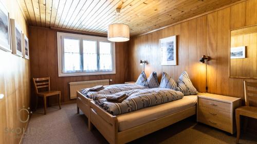 een slaapkamer met een bed in een houten muur bij Haus Alpsegen, Riederalp Alpsegen Riederalp in Riederalp