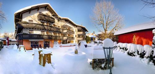 a snow covered street in front of a building at Hotel Hirsch in Oberstaufen