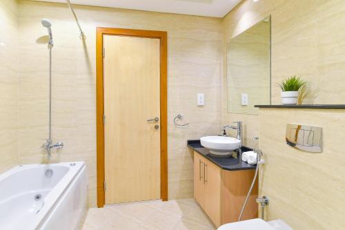 a bathroom with a tub and a sink and a toilet at Scenic High Floor 1BR at Ocean Heights, Dubai Marina by Maxx Value Homes in Dubai