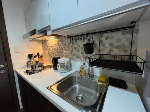 a kitchen with a sink and a counter top at Homey 1 Bedroom Unit at Air Residences in Manila