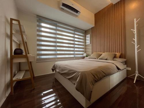 Homey 1 Bedroom Unit at Air Residences في مانيلا: غرفة نوم بسرير كبير ونافذة
