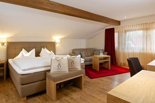 a hotel room with a bed and a couch at Hotel Hirsch in Oberstaufen