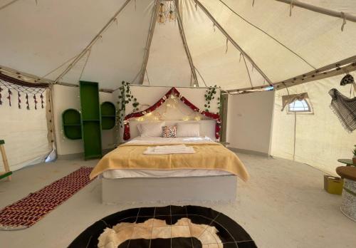 een slaapkamer met een bed in een tent bij Shahrazad Camp in white desert, Egypt in Qasr Al Farafirah