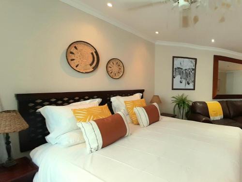 a bedroom with a large white bed with pillows at Beach Road Studio in Cape Town