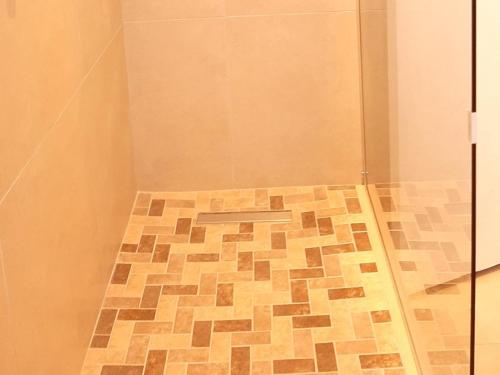 a shower with a tiled floor in a bathroom at Beach Road Studio in Cape Town