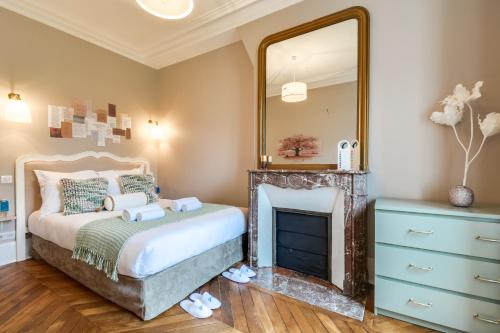 - une chambre avec un lit avec un miroir et une cheminée dans l'établissement Sweett - Pavillon Saint-Germain, à Paris