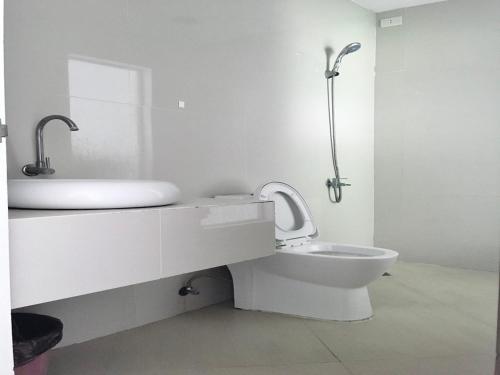 a white bathroom with a sink and a toilet at OYO 921 Sorrento Hotel And Resort 