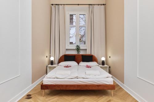 Un dormitorio con una cama con sábanas blancas y una ventana. en The Market Square Siedmiu Elektorów Apartment by Noclegi Renters, en Wroclaw