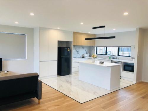 a kitchen with white counters and a black refrigerator at Modern & Luxurious Home 2 in Auckland
