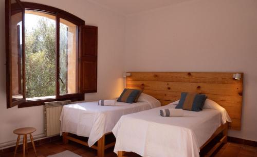 two beds in a room with a window at Es Talaiot in Puigpunyent