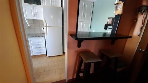 cocina con nevera blanca, mesa y taburete en Vision2000, en Bahía Blanca