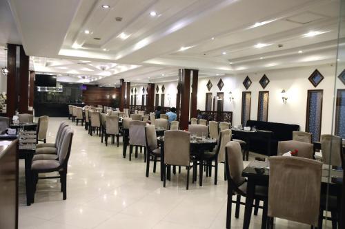 uma sala de jantar cheia de mesas e cadeiras em Hotel Hillview Islamabad em Islamabad