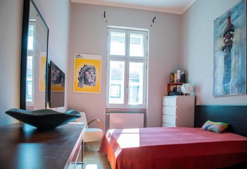 Schlafzimmer mit einem Bett, einem Tisch und einem Fenster in der Unterkunft Stylishly redecorated apartment in great location in Budapest