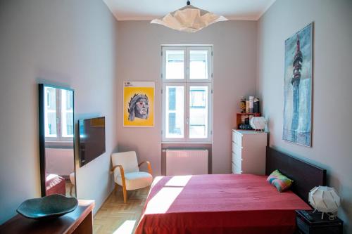 ein Schlafzimmer mit einem großen Bett mit einer roten Decke in der Unterkunft Stylishly redecorated apartment in great location in Budapest