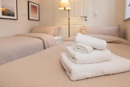 a pile of towels sitting on top of a bed at ErholungNOW in Bispingen