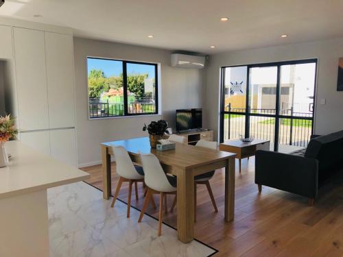 a living room with a table and chairs and a couch at Modern & Luxurious Home 3 in Auckland