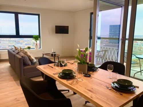 een eetkamer met een tafel en stoelen en een bank bij London Tower Apartments - Antwerp in Antwerpen