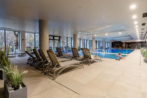pokój przy basenie z krzesłami i basenem w obiekcie Nadmorskie Tarasy w Kołobrzegu Apartament B501 w Kołobrzegu