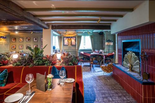 Un restaurante con un sofá rojo y una mesa. en The King's Arms by Innkeeper's Collection, en Knowle