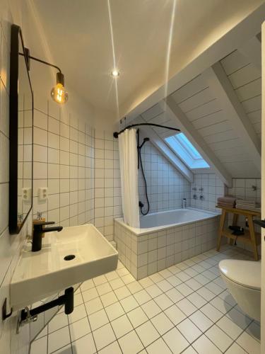 y baño con lavabo y bañera. en Gemütliches Loft en Geretsried