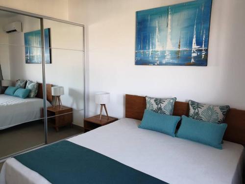 um quarto com uma cama com almofadas azuis em Penthouse vue sur mer 200m2 em Pereybere