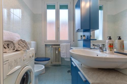 y baño con lavabo y lavadora. en San Donato Fiera Apartment x5! en Bolonia