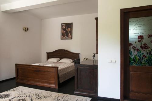 a bedroom with a bed and a sink and a mirror at Pension Andra's House in Horezu