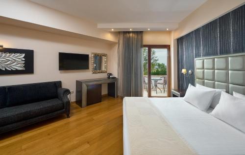 1 dormitorio con cama, sofá y escritorio en Mediterranean Princess- Adults Only, en Paralia Katerinis