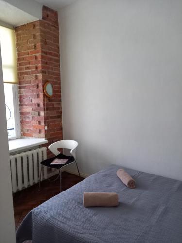 a bedroom with a bed with a blue blanket and a chair at Old Town Charm TLN in Tallinn