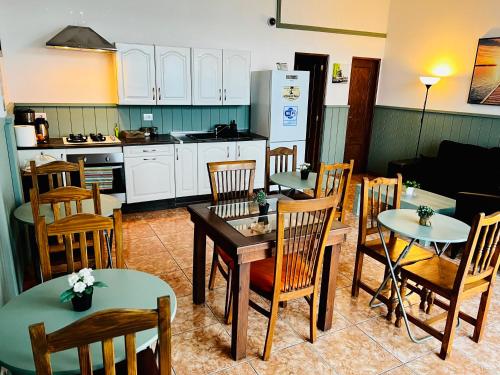 een keuken en eetkamer met tafels en stoelen bij El jardin de Iris in Santa Cruz de Tenerife