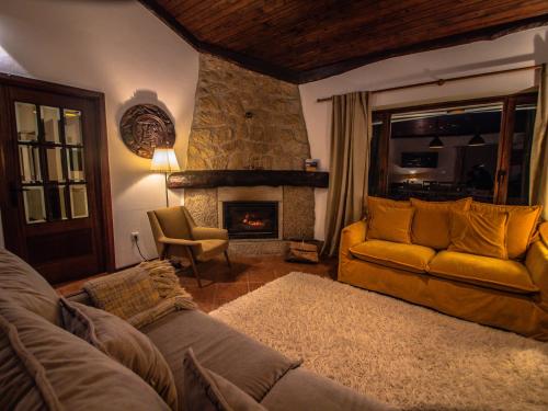 a living room with a couch and a fireplace at Casa da Terra Nova - Gerês in Rio Caldo