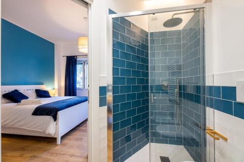 a blue tiled shower in a bedroom with a bed at Bed & Breakfast Across The Room(e) in Rome