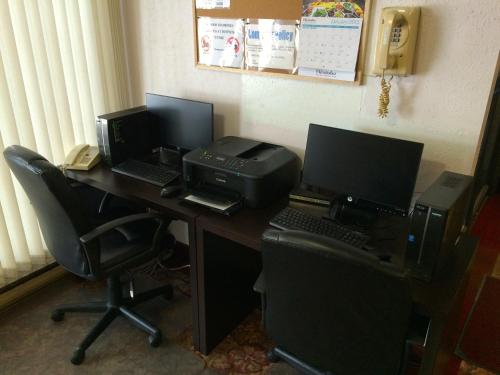 a desk with two computer monitors and a printer at Colonial Inn in Brandon