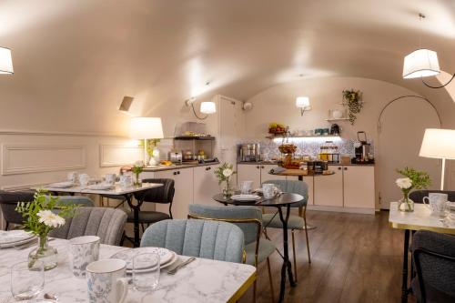 un restaurant avec des tables et des chaises et une cuisine dans l'établissement Hôtel Madeleine Haussmann, à Paris