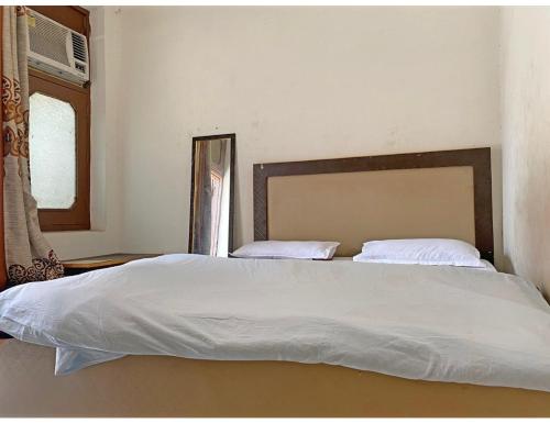 a bedroom with a large bed with white sheets at Satkar Homestay, Saharanpur in Sahāranpur