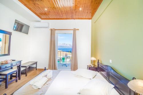 a bedroom with a bed and a desk and a window at Vergina Star Hotel in Nikiana