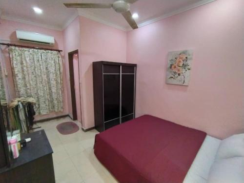 a bedroom with pink walls and a bed and a couch at Comfort Home Rawang in Rawang