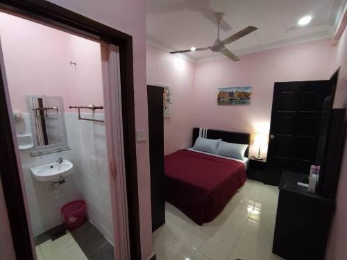 a bedroom with a bed and a sink and a ceiling fan at Comfort Home Rawang in Rawang
