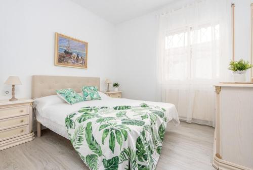 a bedroom with a bed with a green and white blanket at Empurialola - Casa todo confort, con piscina, cerca de la playa y centro - 131 in Empuriabrava