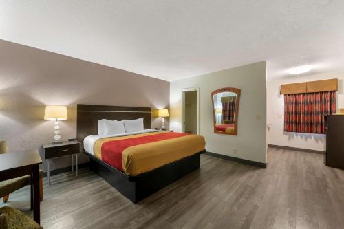 a hotel room with a large bed and a table at Econo Lodge Hollywood - Ft Lauderdale International Airport in Hollywood