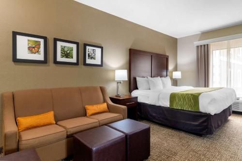 a hotel room with a bed and a couch at Comfort Inn & Suites in Griffin
