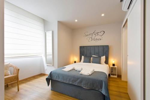um quarto com uma cama grande e um cobertor azul em APOSENTUS - Marta's House em Porto