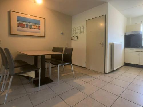 a dining room with a table and chairs and a refrigerator at Wijk de Brabander 59 in Cadzand
