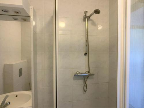 a shower with a glass door next to a sink at Wijk de Brabander 59 in Cadzand