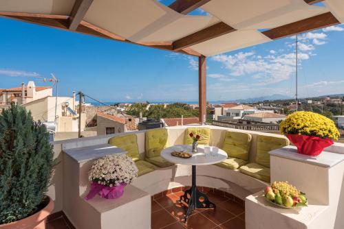 een patio met een tafel en stoelen op een balkon bij Calergi Residence in Atsipopoulo