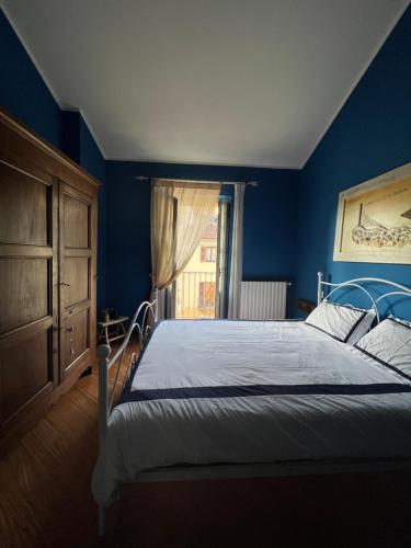 una camera da letto con un letto con pareti blu e una finestra di La casa dei pescatori a Torino