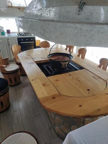 a kitchen with a wooden table with a pot on a stove at Apartman OGNJIŠTE in Kupres