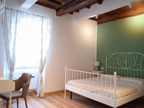 - une chambre avec un lit blanc et un mur vert dans l'établissement Il Giardino di Ambra Casa Vacanze indipendente, à Viterbe